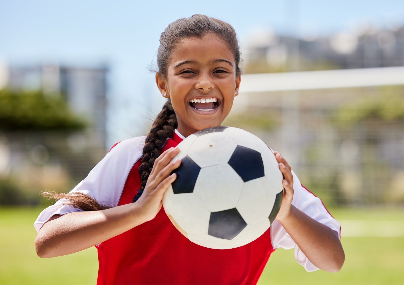 Girl holding up soccer ball